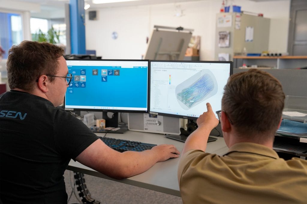 Home DE 3 Zwei Ingeneure vor einem PC beurteilen eine Flow Simulation für ein Extrusionswerkzeug für Kunststoffprofile